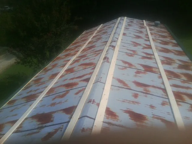 Rusted metal roof panels with new wood purlins before replacement — Storm Damage Roof Repair in Palmer by Roofing Brothers