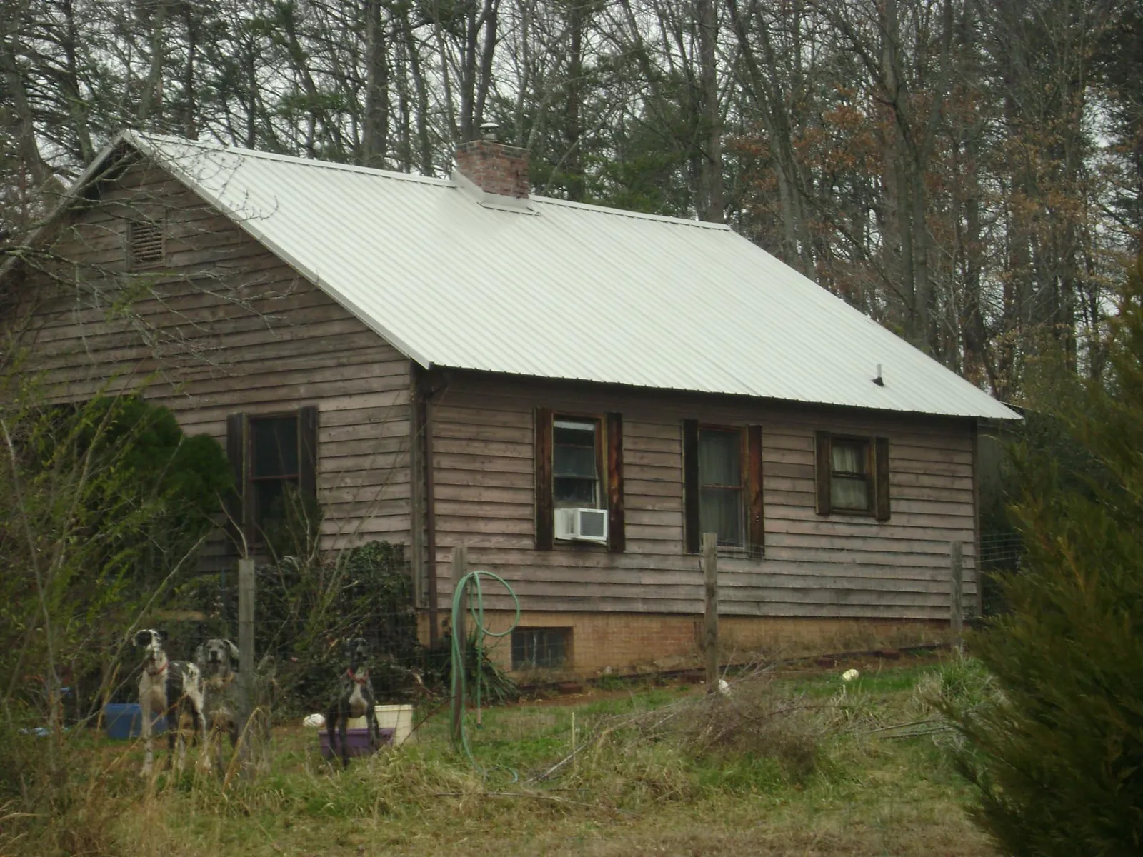 White metal roof on an old wood sided farmhouse, from a Metal Roof Installation job in Palmer